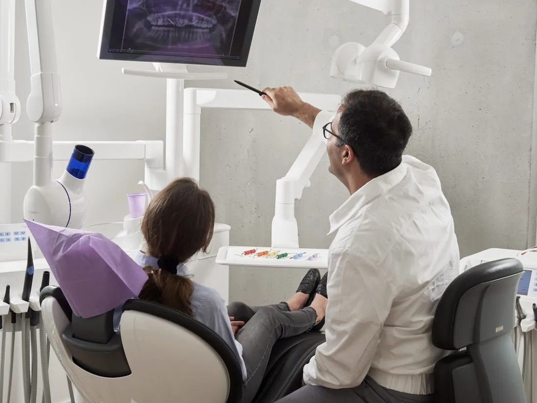 Dentista mostrando radiografia ao paciente em clínica moderna